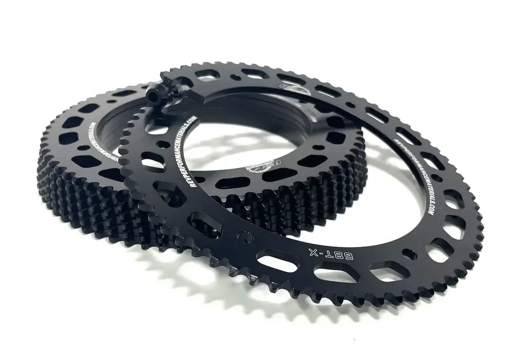 A Stack of Black Rev #219 Karting Rear Twist Sprockets with One Leaning on the Rest of Them.